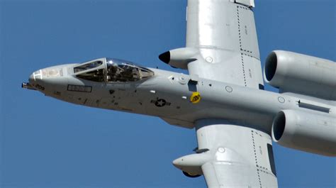 A-10 Warthog landing on rough airstrip with visible rugged landing gear and dusty terrain