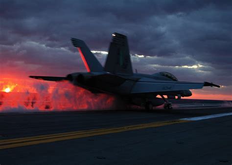 A U.S. Navy Super Hornet taking off with afterburners engaged
