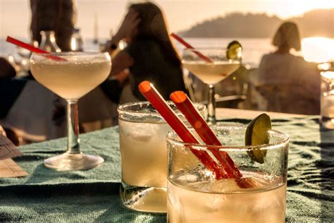Adults enjoying complimentary drinks on the shaded upper deck while children play below