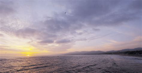Aerial sunset over Malibu coastline with helicopter in silhouette