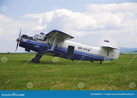 Aging An-2 biplane delivering cargo in rural Siberian village, landing on dirt airstrip