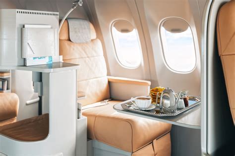 aging passenger in first class seat with glass of champagne and newspaper