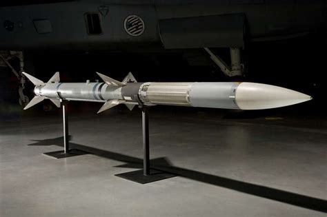 AIM-120D AMRAAM missile displayed at military aviation exhibition with cutaway guidance section