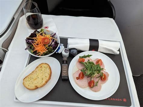 air canada signature class lie-flat seat with amenity kit and dinner service