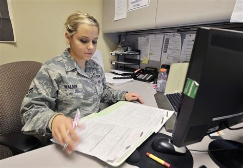 air force airman reviewing aircrew flight qualification files in resource management office