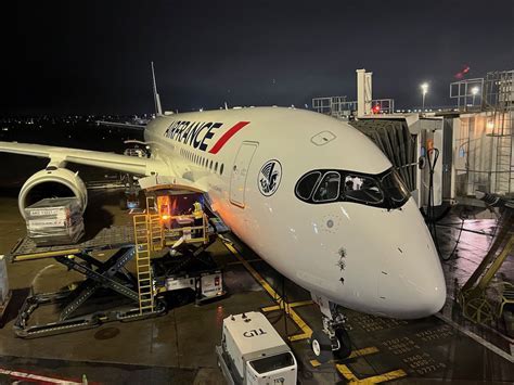air france pilot walking toward klm 777 parked at new york jfk gate