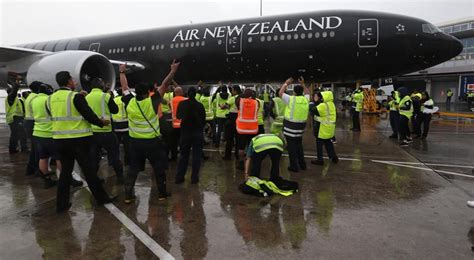 air new zealand ground crew assisting winter travelers at auckland terminal