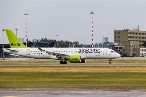 airBaltic Airbus A220 fleet lined up at Riga International Airport during sunset