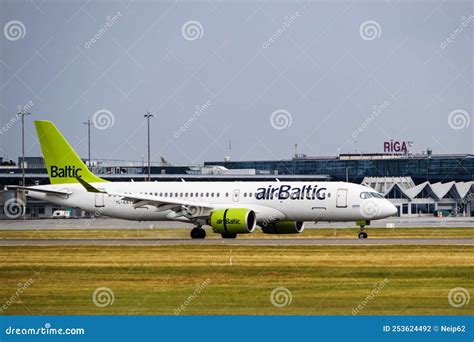 airBaltic aircraft taxiing on tarmac with sunset background at Riga Airport
