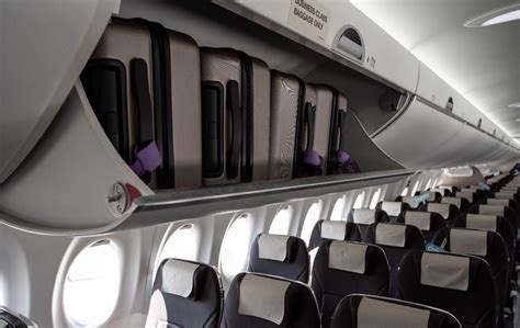Airbus A220 pivot overhead bins storing carry-on luggage