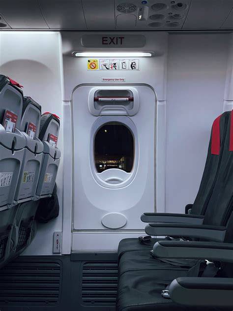 Airbus A350-900 cabin crew restraining disruptive passenger near emergency exit door