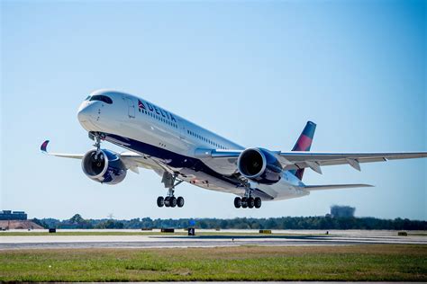 Airbus A350 takeoff rotation with landing gear retracting at sunrise