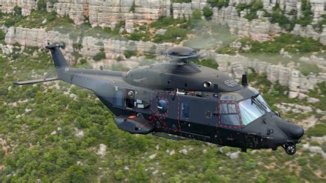 Airbus NH90 tactical transport helicopter military flight over mountains