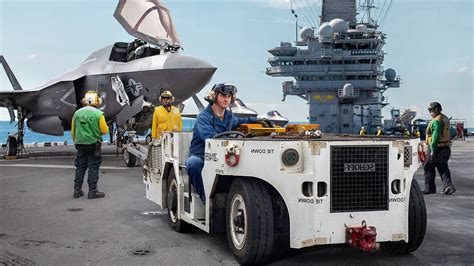 aircraft carrier deck crew working on anti-skid coated steel flight deck