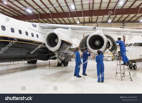 aircraft maintenance crew inspecting Boeing 747 engines hangar