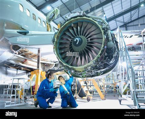 aircraft maintenance technician inspecting turbine engine at night shift