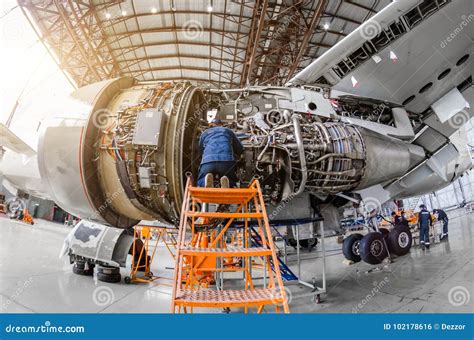 aircraft maintenance technician working on jet engine hangar