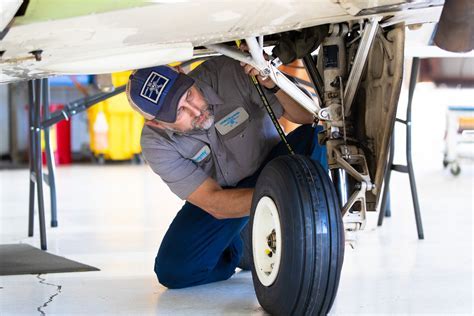 aircraft mechanic conducting annual inspection on landing gear