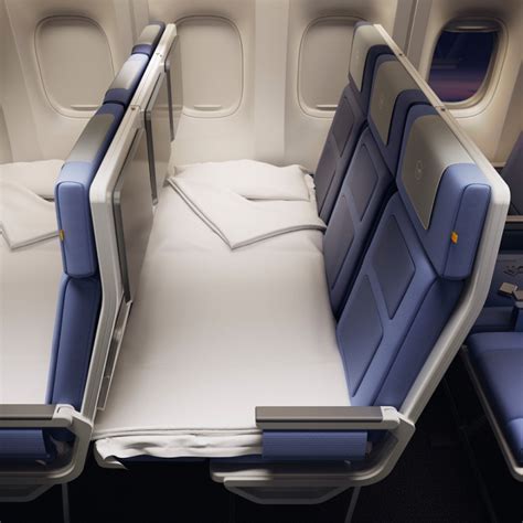 airline crew preparing economy bed setup with bedding inside cabin