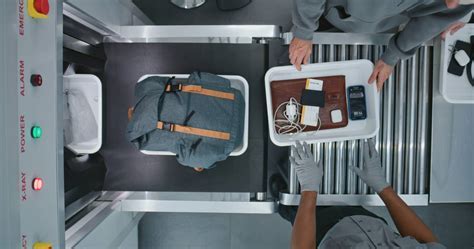 airline flight attendant inspecting passenger carry on bag lithium battery safety check