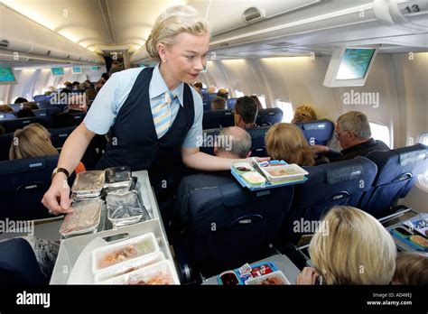airline flight attendant serving economy cabin passengers real service interaction