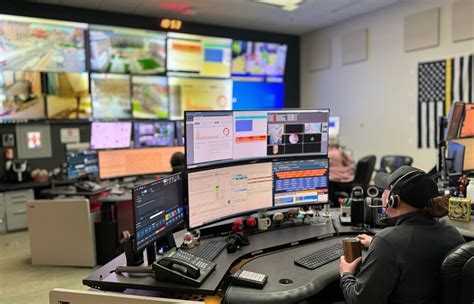 airline operations center at a major hub, multiple dispatchers coordinating flights on large monitors