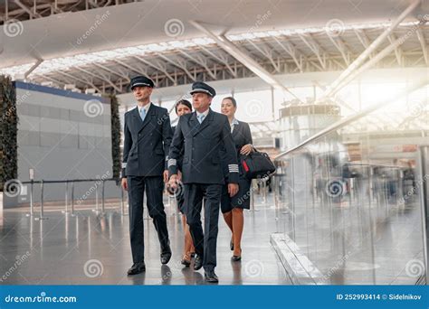 airline pilot walking through airport terminal in uniform