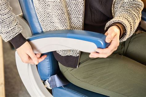 airplane aisle seat armrest hidden button mechanism close detail