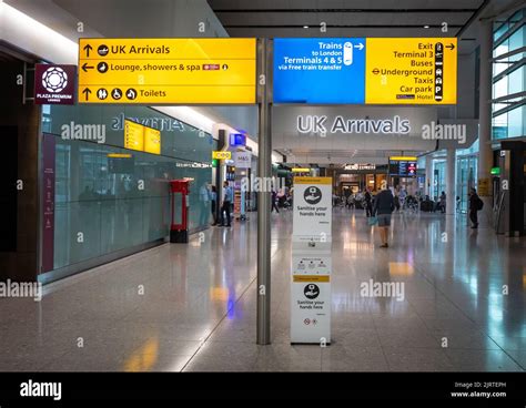 airport customs hall arriving international passengers luggage conveyor belts overhead signage crowded arrival area