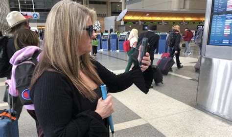 airport departure board and visually impaired passenger using smartphone navigation