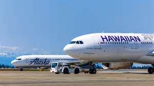 Alaska Air Group and Hawaiian Airlines aircraft parked together at Honolulu airport gates