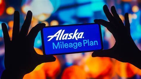 Alaska Airlines loyalty card and mobile app open showing Mileage Plan miles balance