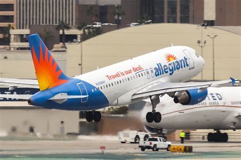 allegiant air plane taking off from regional airport at sunset