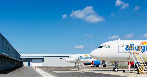 Allegiant maintenance crew servicing Airbus A320 in nighttime operations hangar
