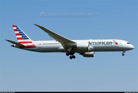 American Airlines B787-9P tail fin with DFW runway in the background