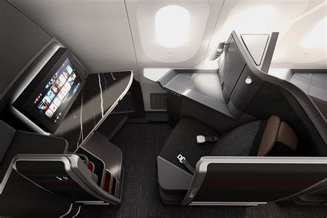 American Airlines Flagship Suite business-class seat with sliding privacy door, lie-flat bed, personal storage, and premium cabin lighting