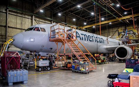 american airlines maintenance hangar at night with engineers inspecting aircraft wing
