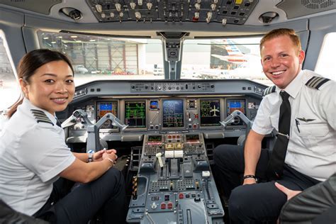 American Airlines pilot waving American and New Zealand flags from cockpit window upon landing in Auckland