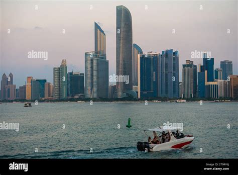 american couple overlooking abu dhabi skyline at sunset from rooftop