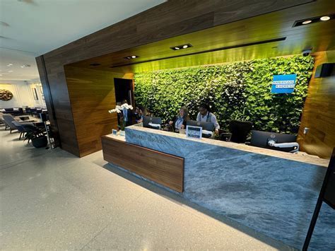 Amex staff at DCA lounge front desk handling check-in and managing waitlist