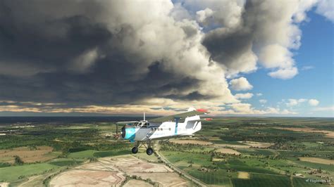 Antonov An-2 Colt biplane flying low over rural landscape