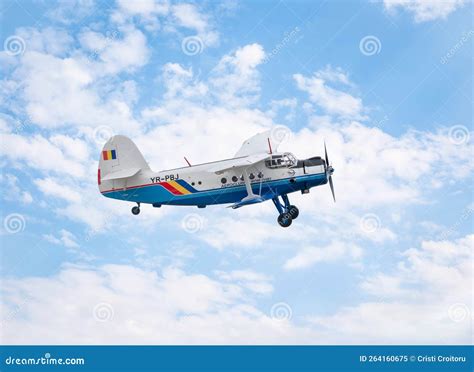 Antonov An-2 flying at low altitude in windy conditions over open field