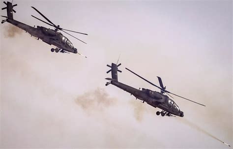 Apache helicopter hovering in combat exercise with full weapon load, Iraq 2022