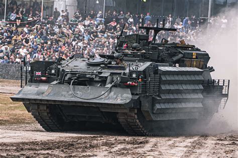 Armored recovery vehicle performing field repair on damaged tank track