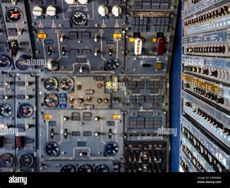 avionics technician configuring electronic control panel inside aircraft cockpit