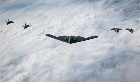b-2 stealth bomber flying above clouds