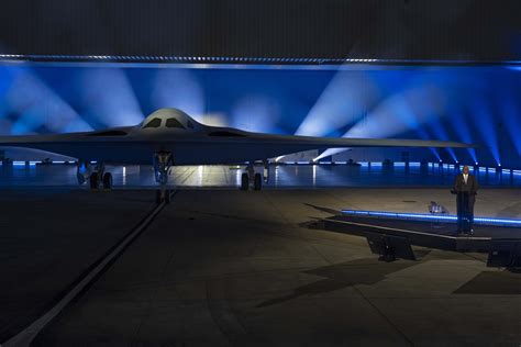 B-21 Raider stealth bomber rollout at hangar with advanced lighting