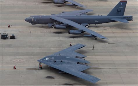 B-52 parked on runway with ground crew preparing munitions