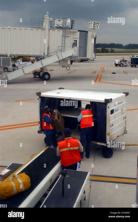 baggage handlers loading suitcases into aircraft cargo hold during winter