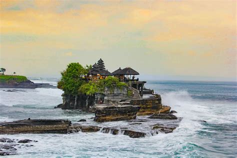 Balinese temple at Tanah Lot during golden hour with waves crashing